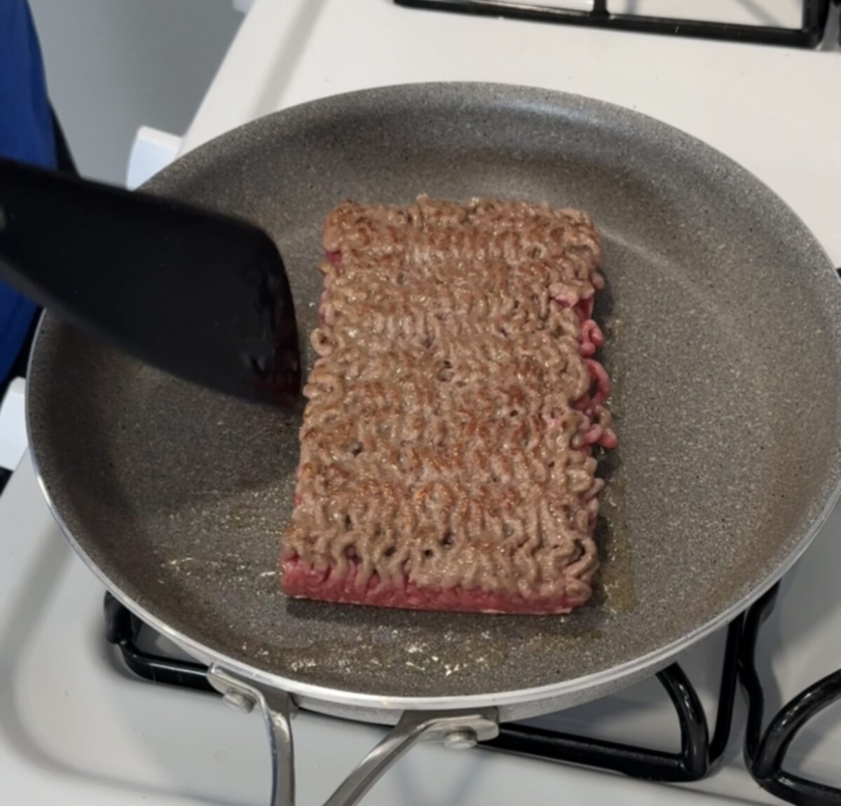 Browning ground beef in a large nonstick skillet on the stovetop.