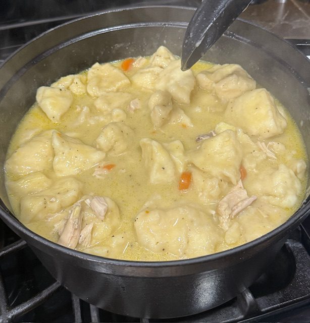 Easy chicken and dumplings with biscuits is finished in the pot and ready to serve. 
