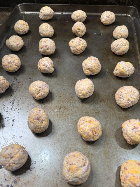 Old bay sausage balls are roll into nice balls and evenly spaced on a baking sheet.