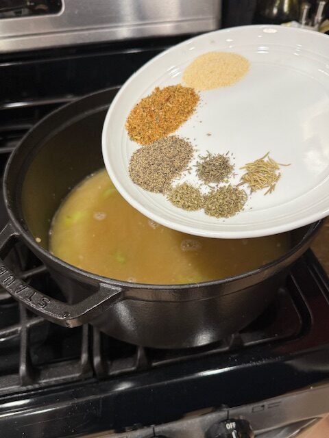Seasonings for creamy chicken noodles are on a white plate and ready to add into the dutch oven. 