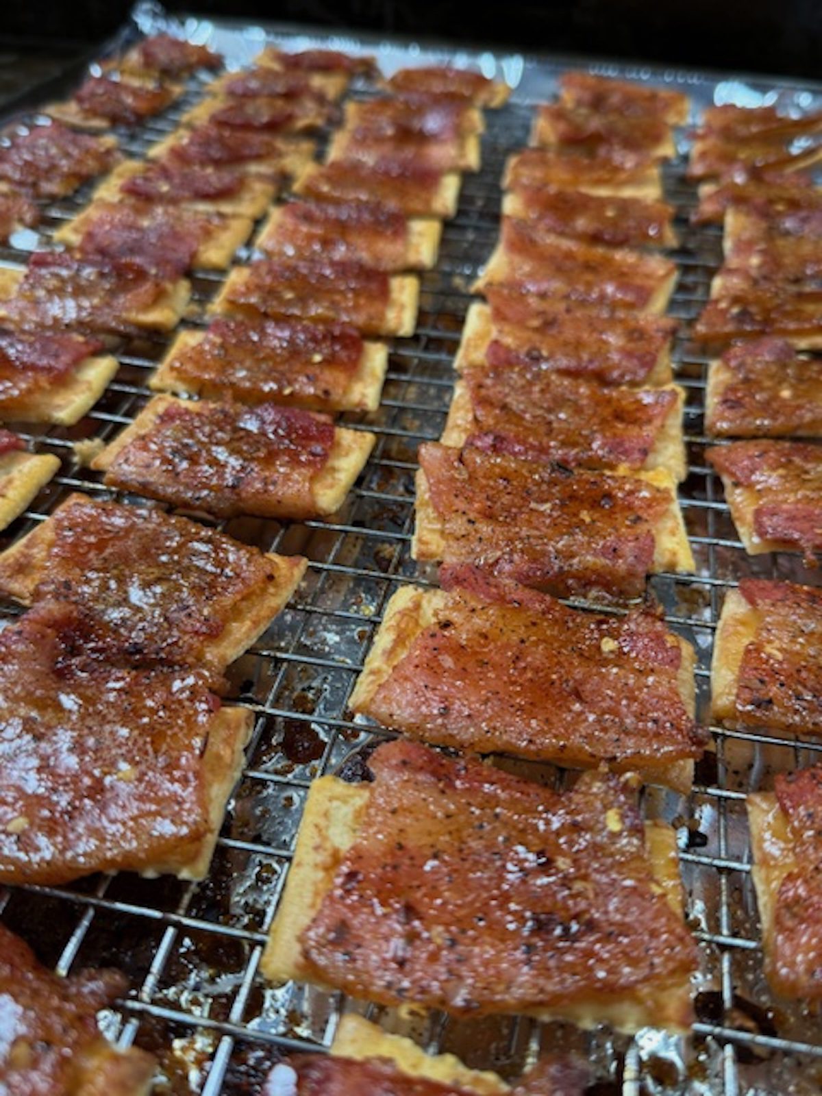 Bacon crackers are baked and resting on a wire rack.