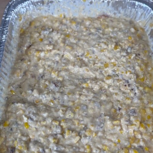 Baked cheesy bacon corn dip in the silver tray.
