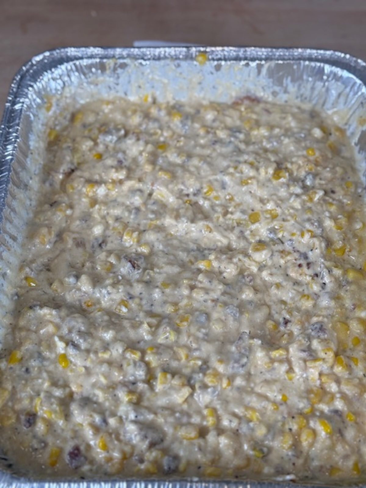 Baked cheesy bacon corn dip in the silver tray.