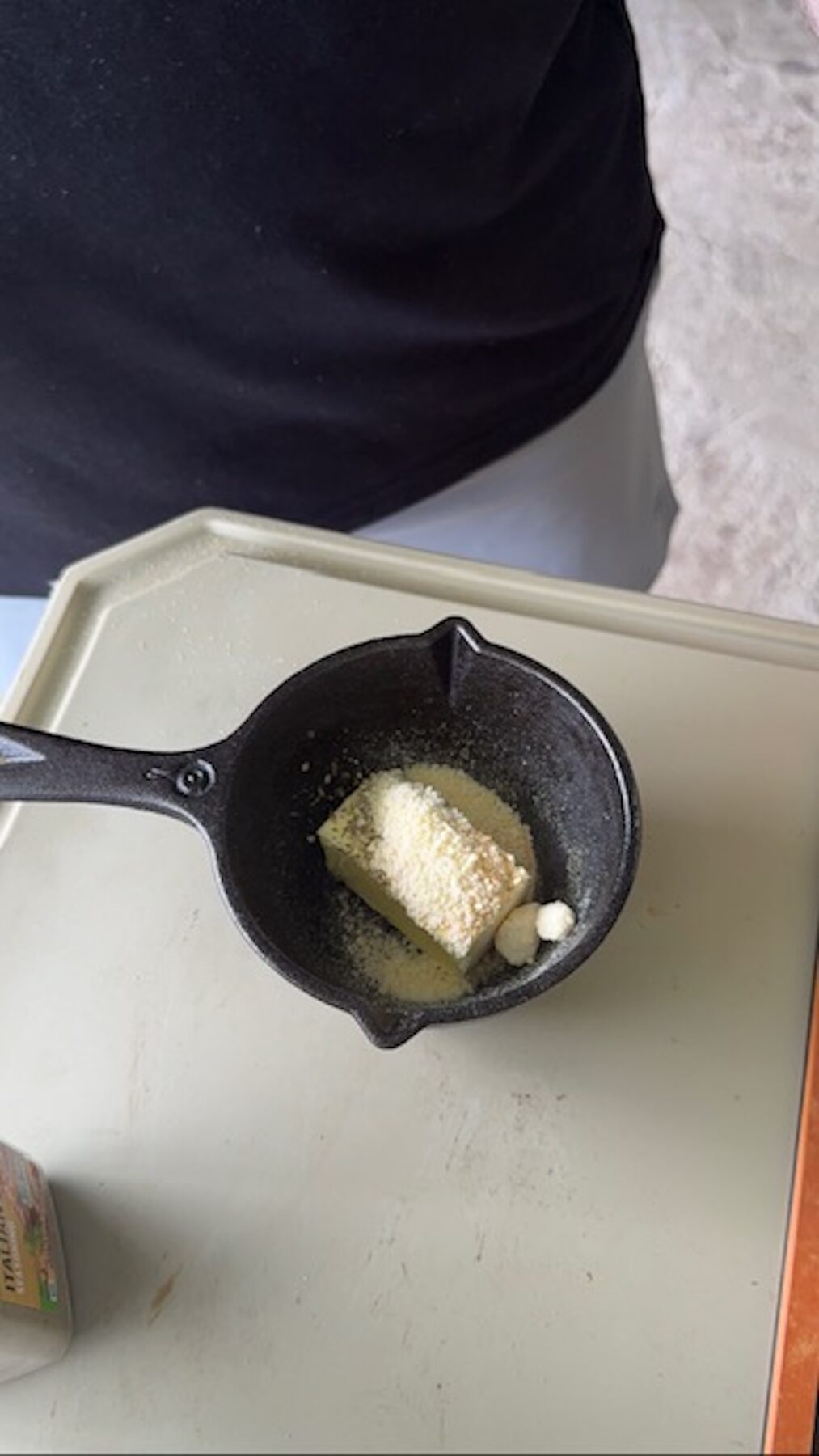 A small skillet with butter and spices.