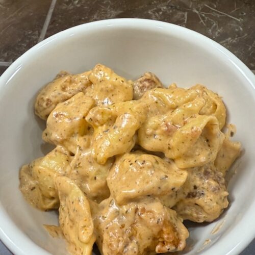 A white bowl of marry me chicken pasta.