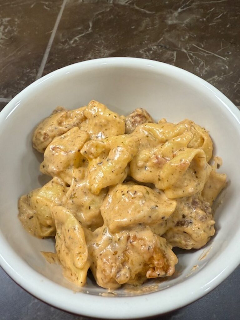 A white bowl of marry me chicken pasta.