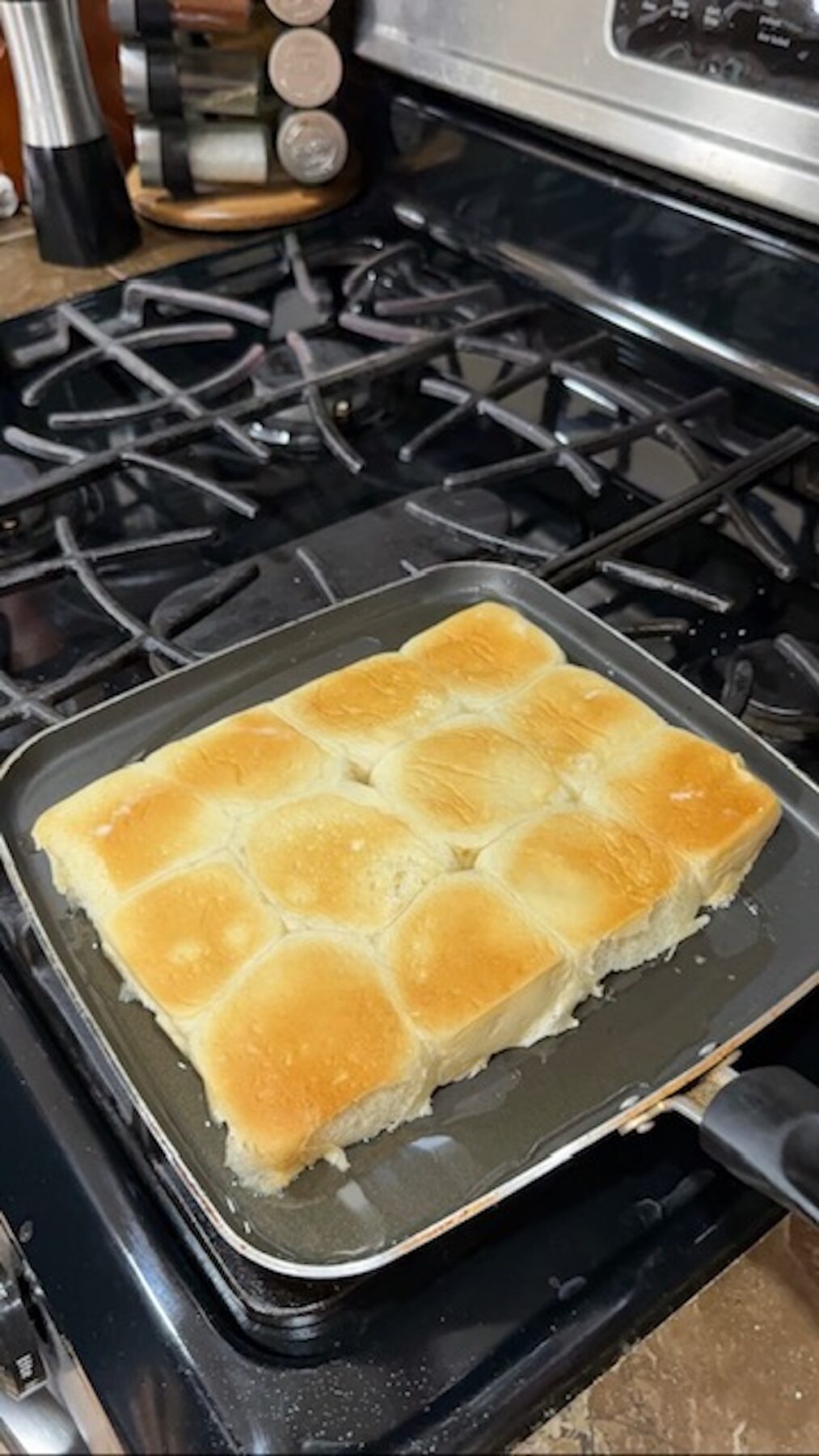 Sliders on a skillet being toasted on the stove.