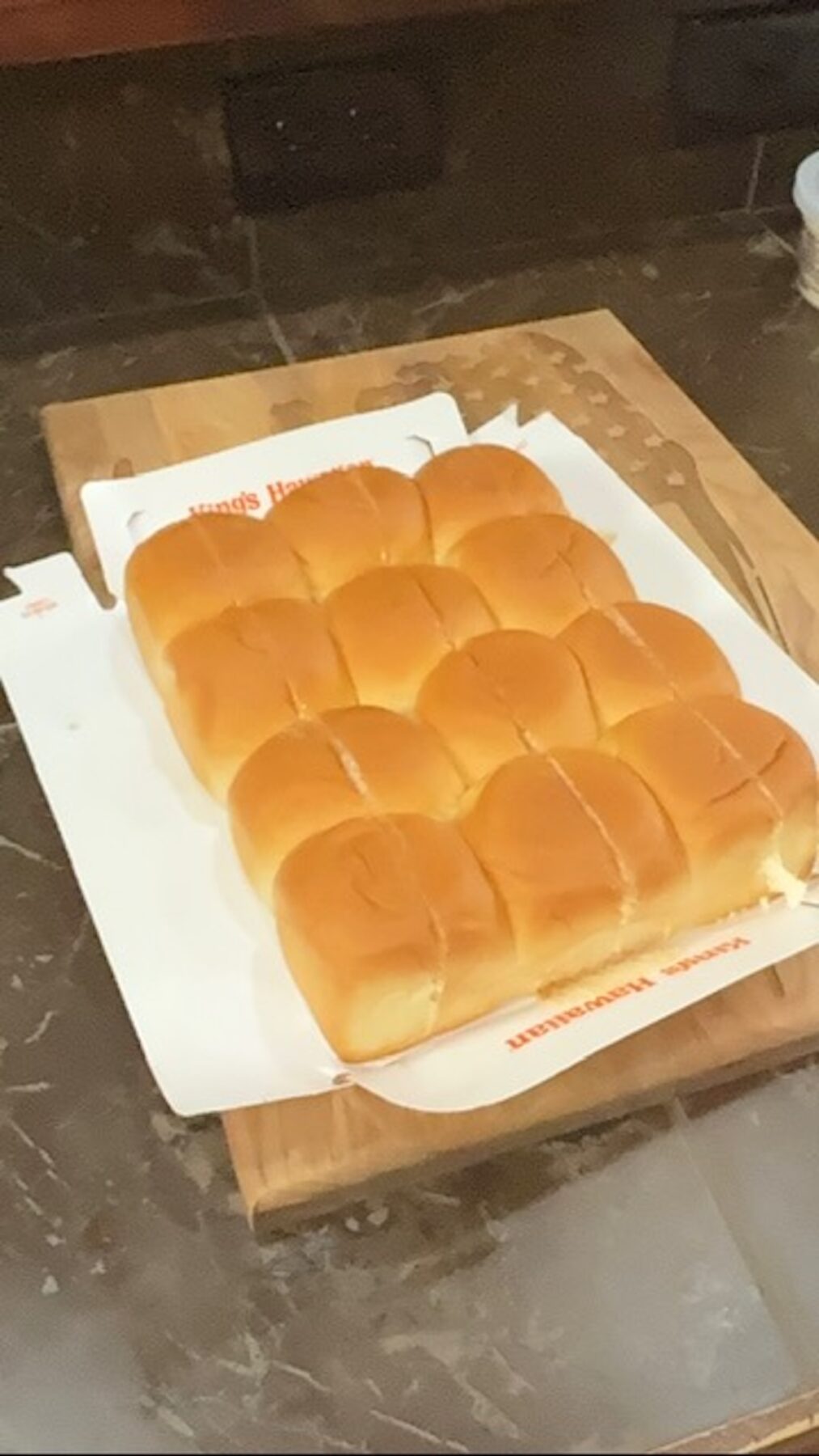 Sweet Hawaiian slider rolls in the package on a cutting board.