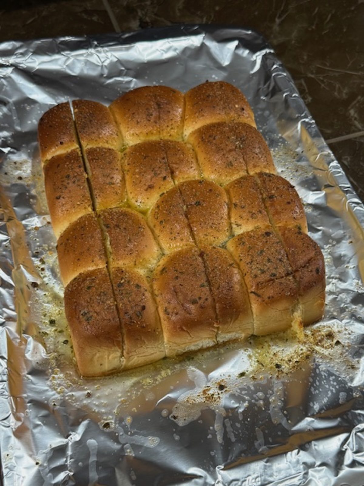 Chicken parm sliders toasted with spices on top on a foil-lined baking sheet.