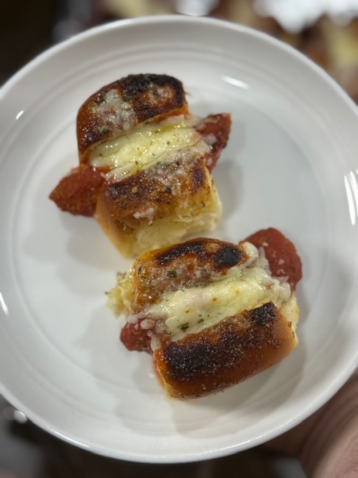 Baked chicken parm sliders on a white plate.