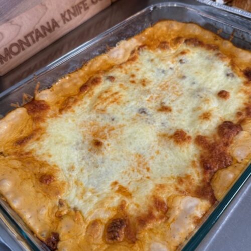 Baked million dollar tortellini bake in a glass baking dish.