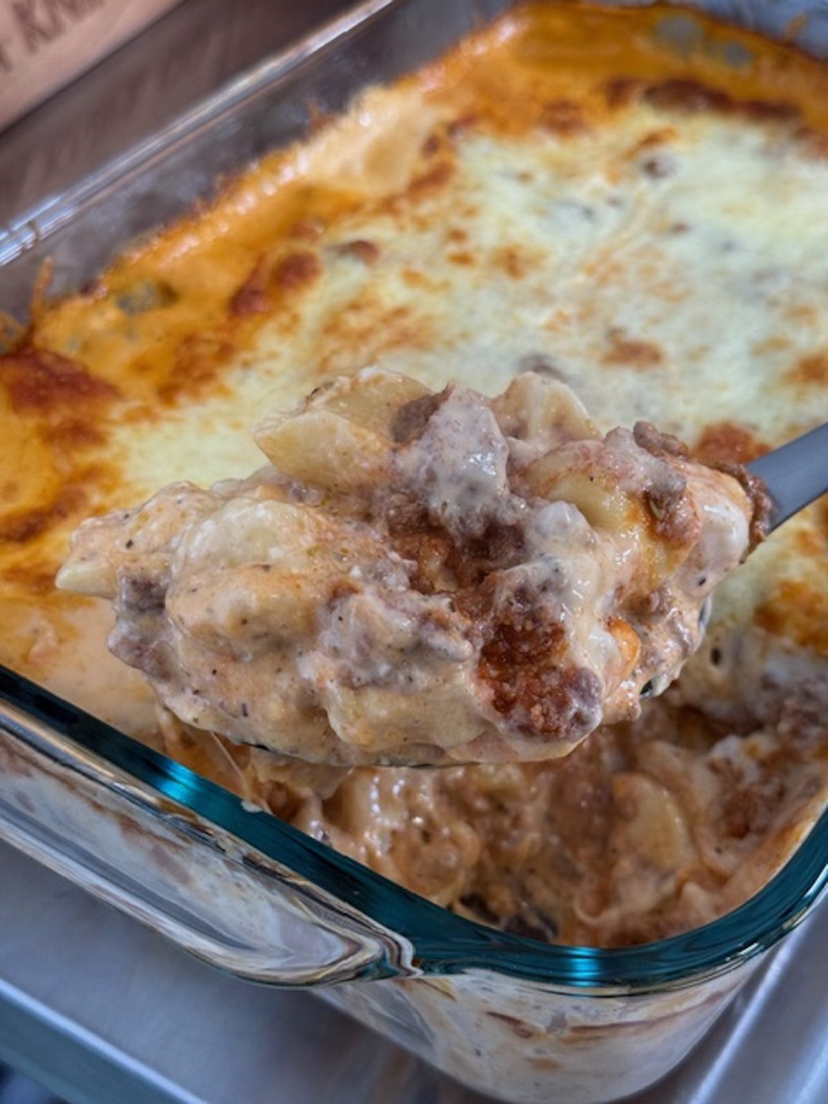 A spoon is scooping out the million dollar tortellini bake.