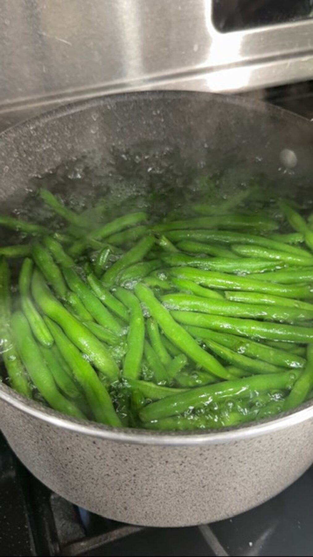 Green beans boiling in a pot.