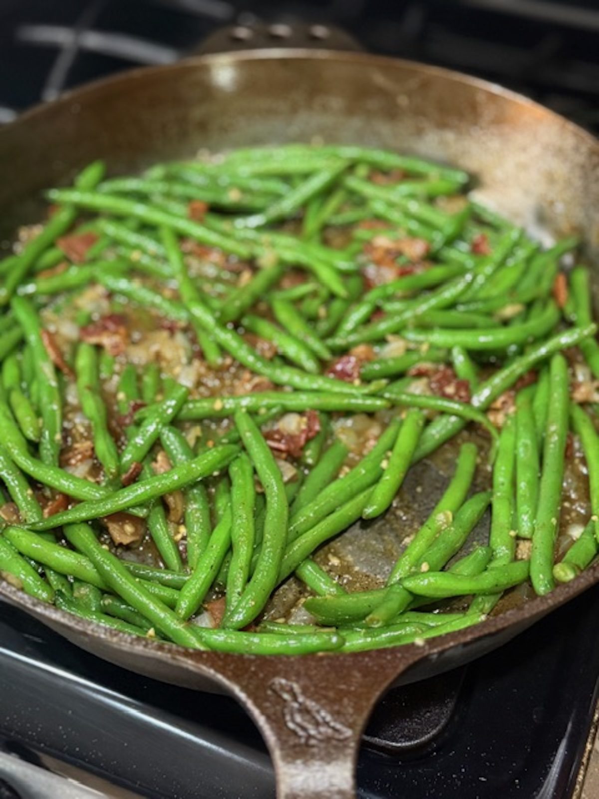 Green beans with bacon in a skillet.