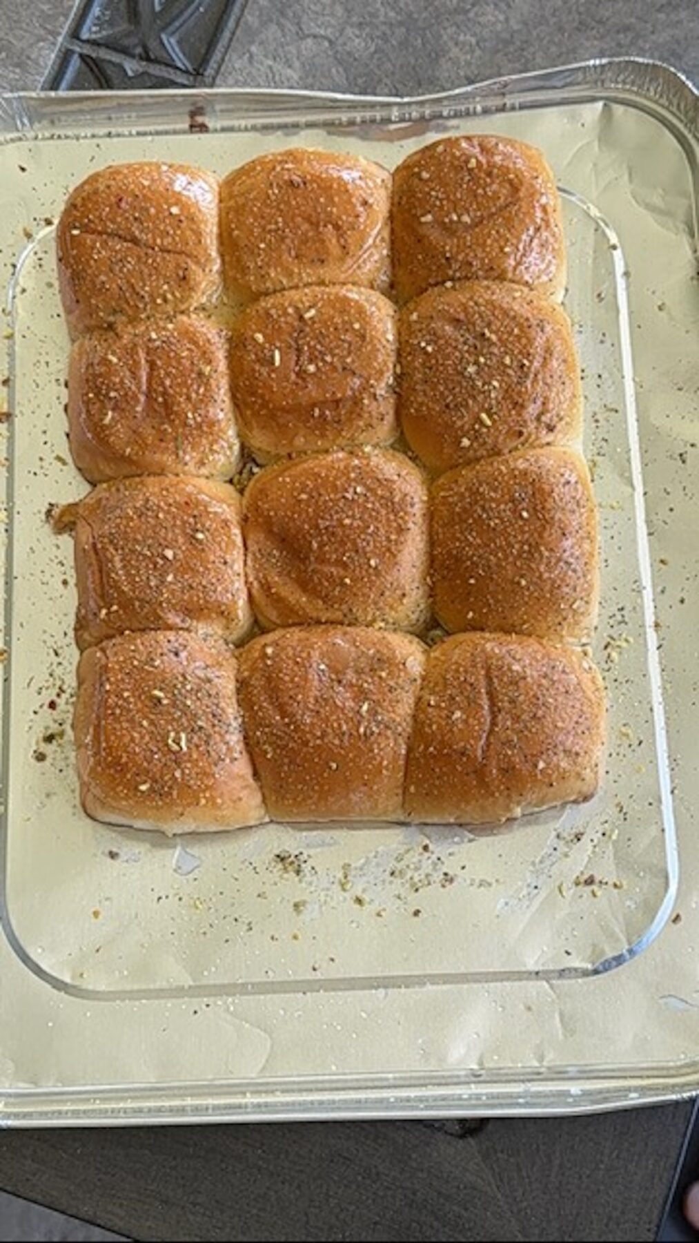 Slider bun tops are brushed with butter and sprinkled with spice blend.