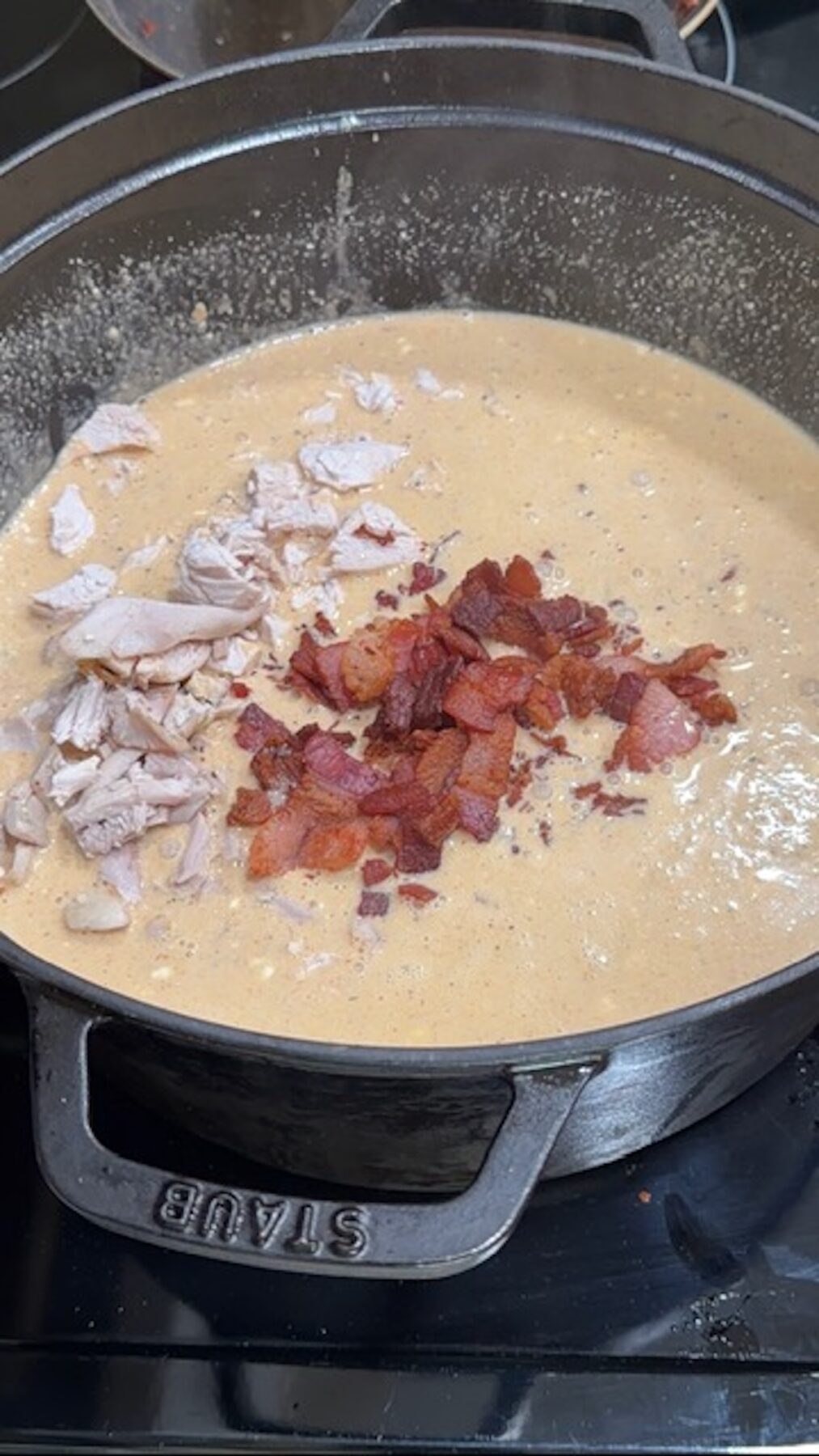 Crack chicken soup in a dutch oven with piles of chopped chicken and cooked bacon on top.