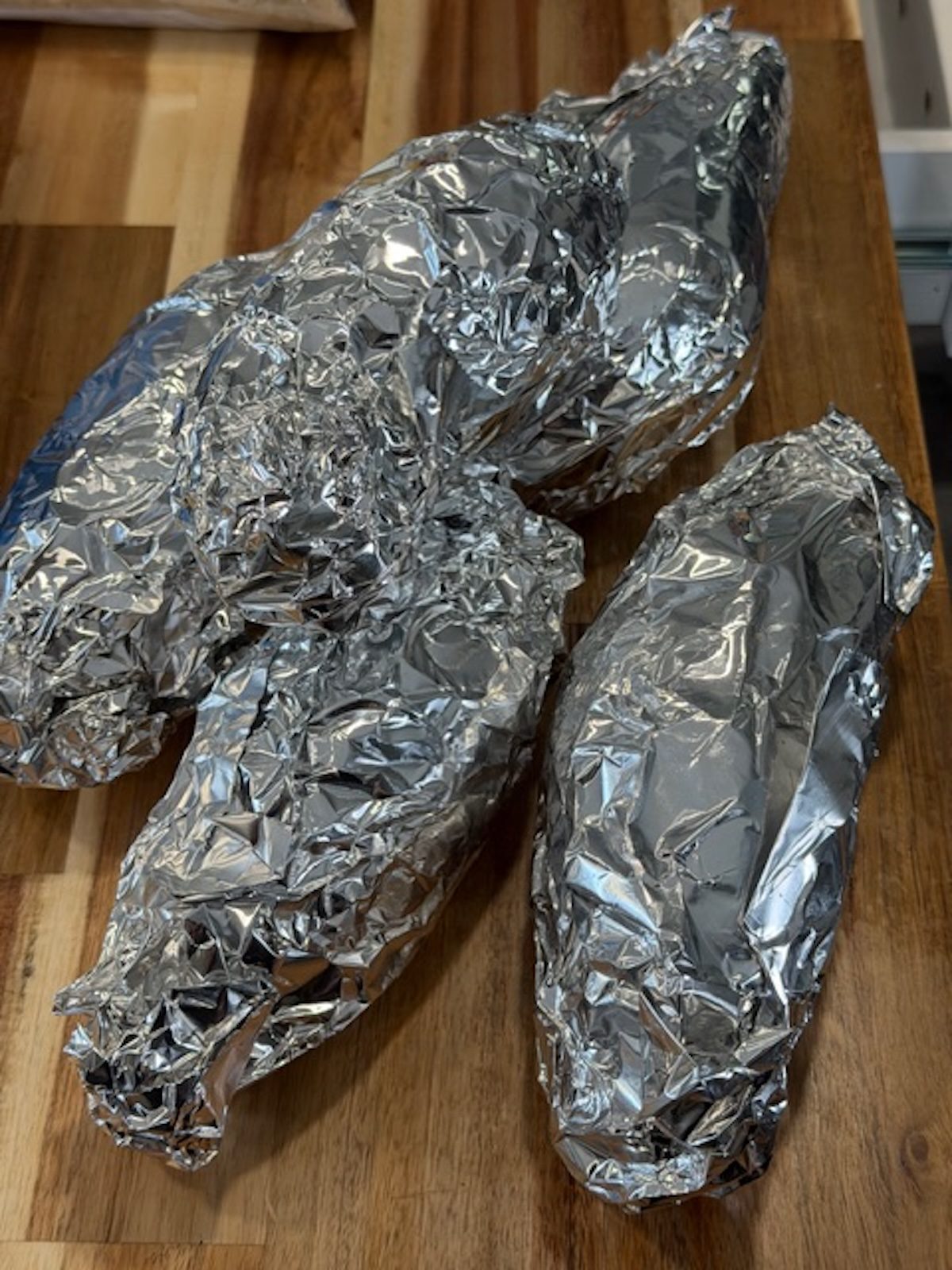 Sweet potatoes wrapped in foil.