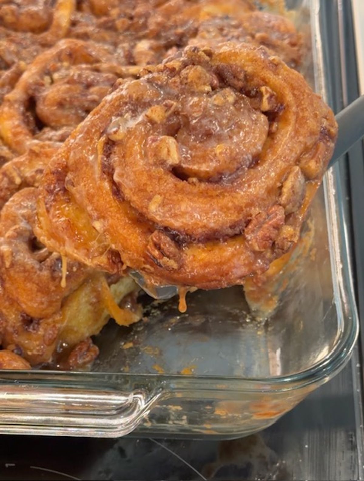 A spatula lifting out an easy cinnamon roll.