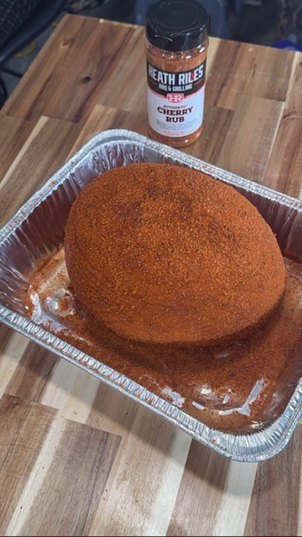 Ham in a foil tin with spice rub on it.