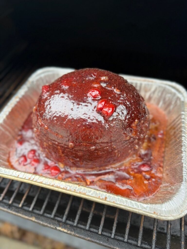 coca cola ham with glaze in foil tin on the grill.