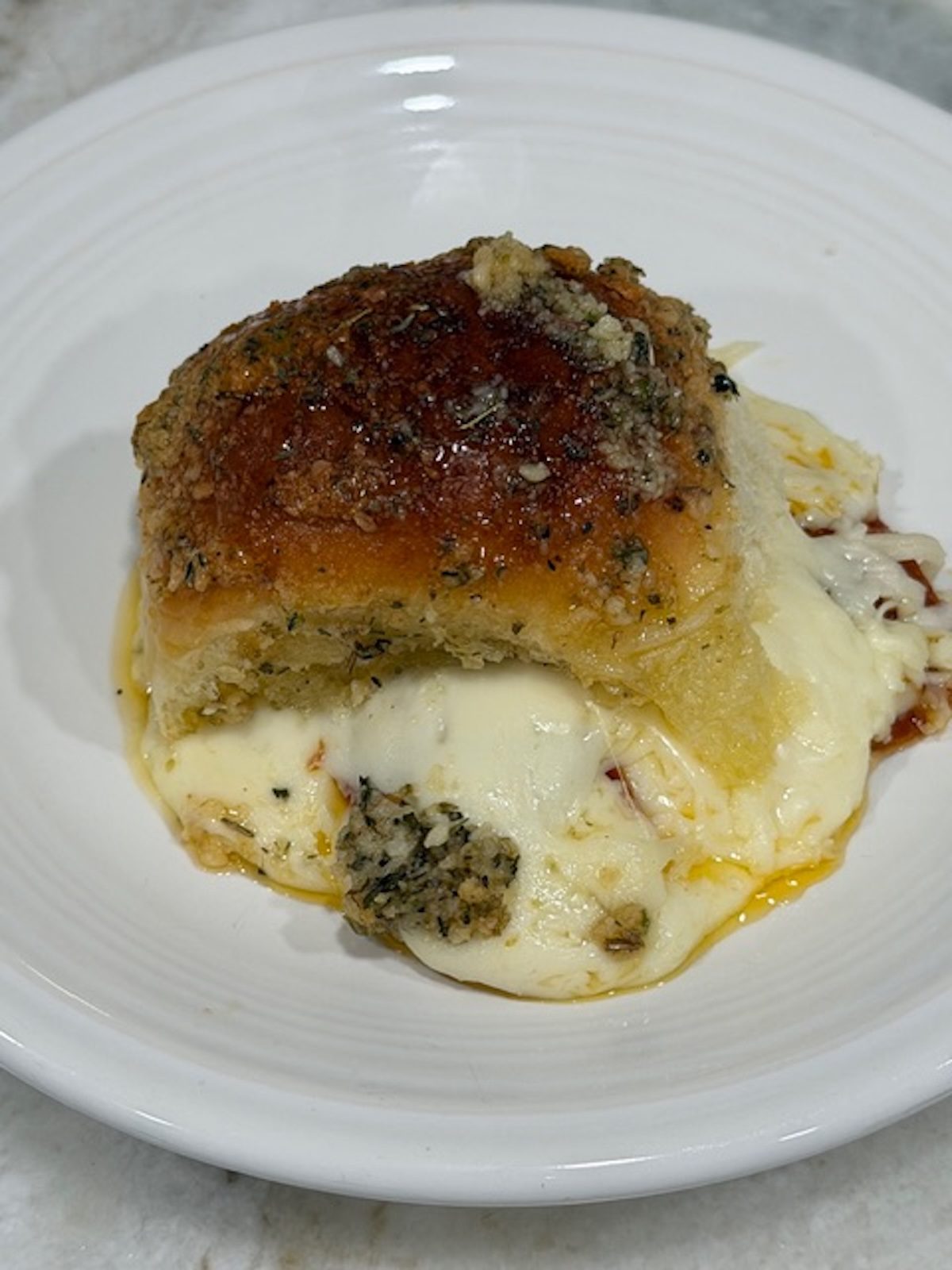 A pepperoni pizza slider on a white plate.