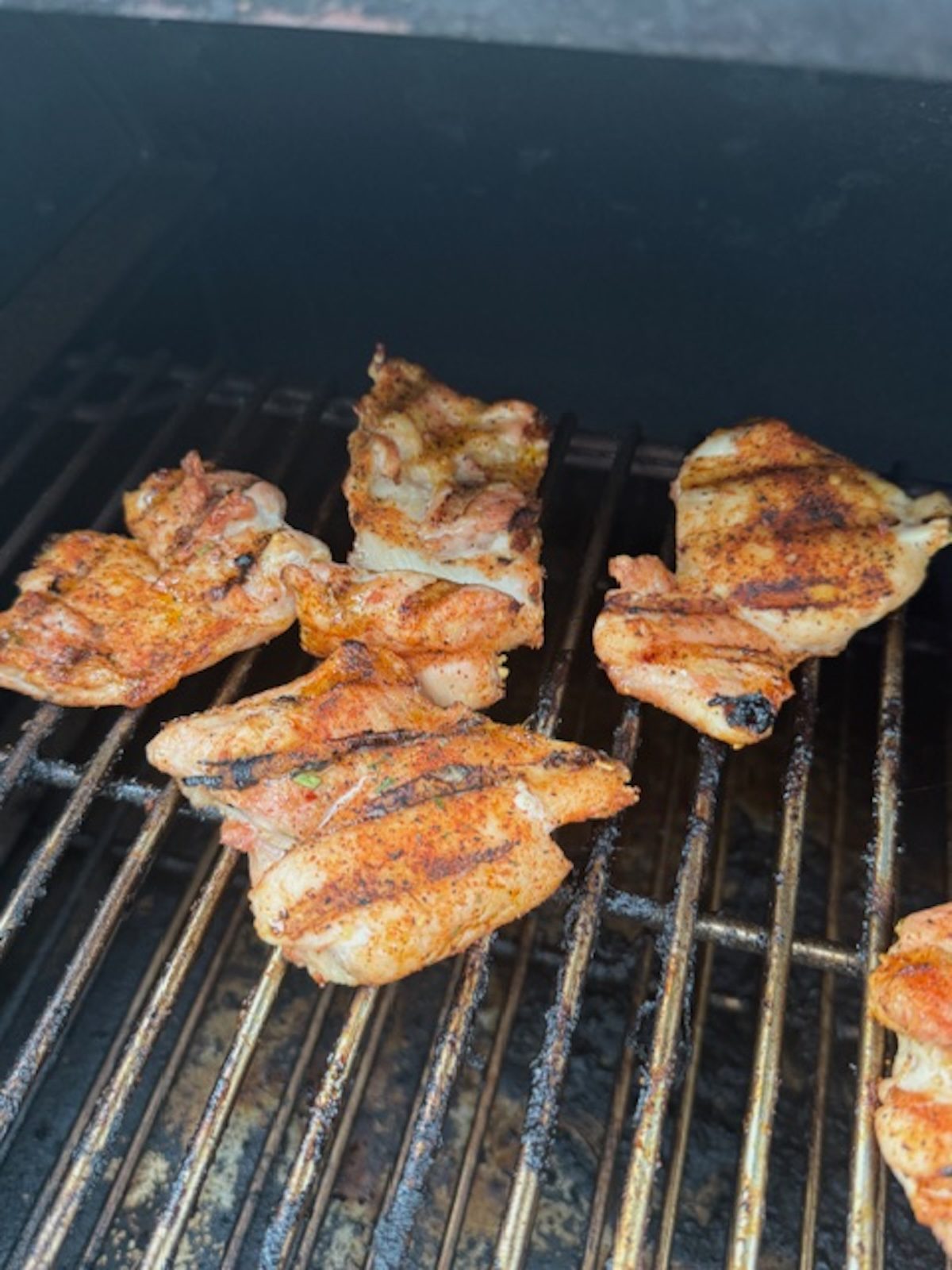 A grill with chicken grilling.