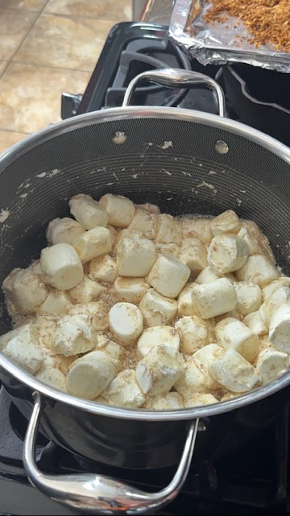 A large pot with marshmallows and butter melting on the stovetop.