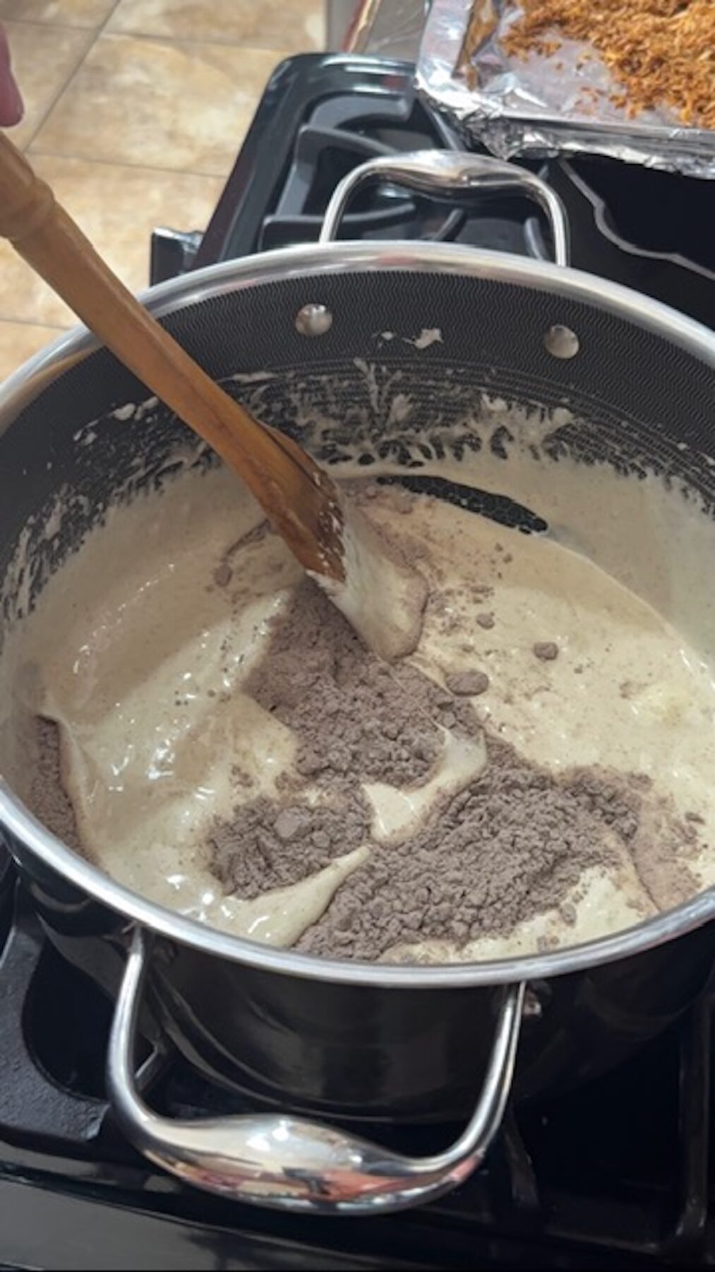 Melted marshmallows and spices in a large pot with a wooden spoon.