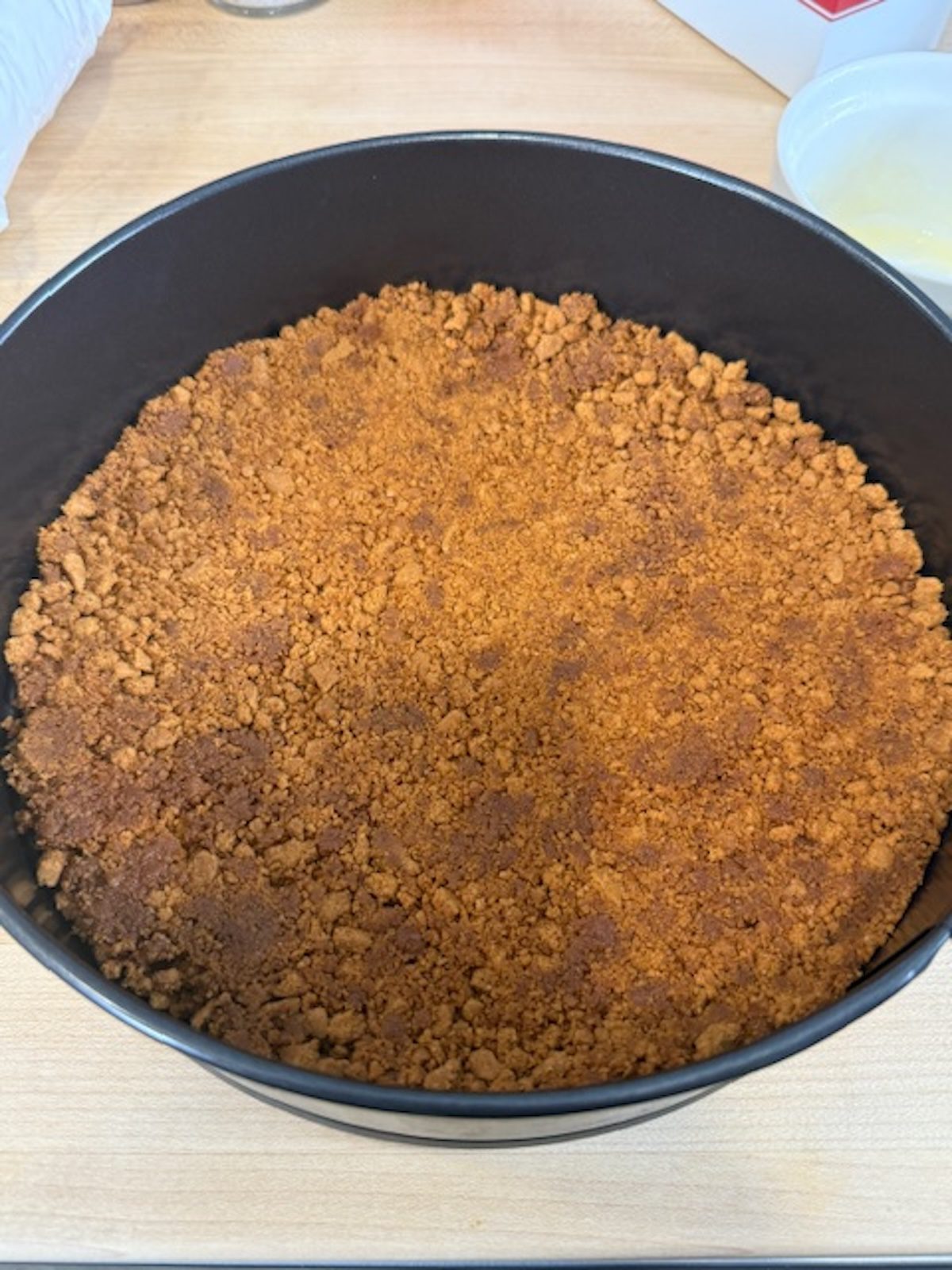 A cake pan with no bake biscoff cookie crumbs.