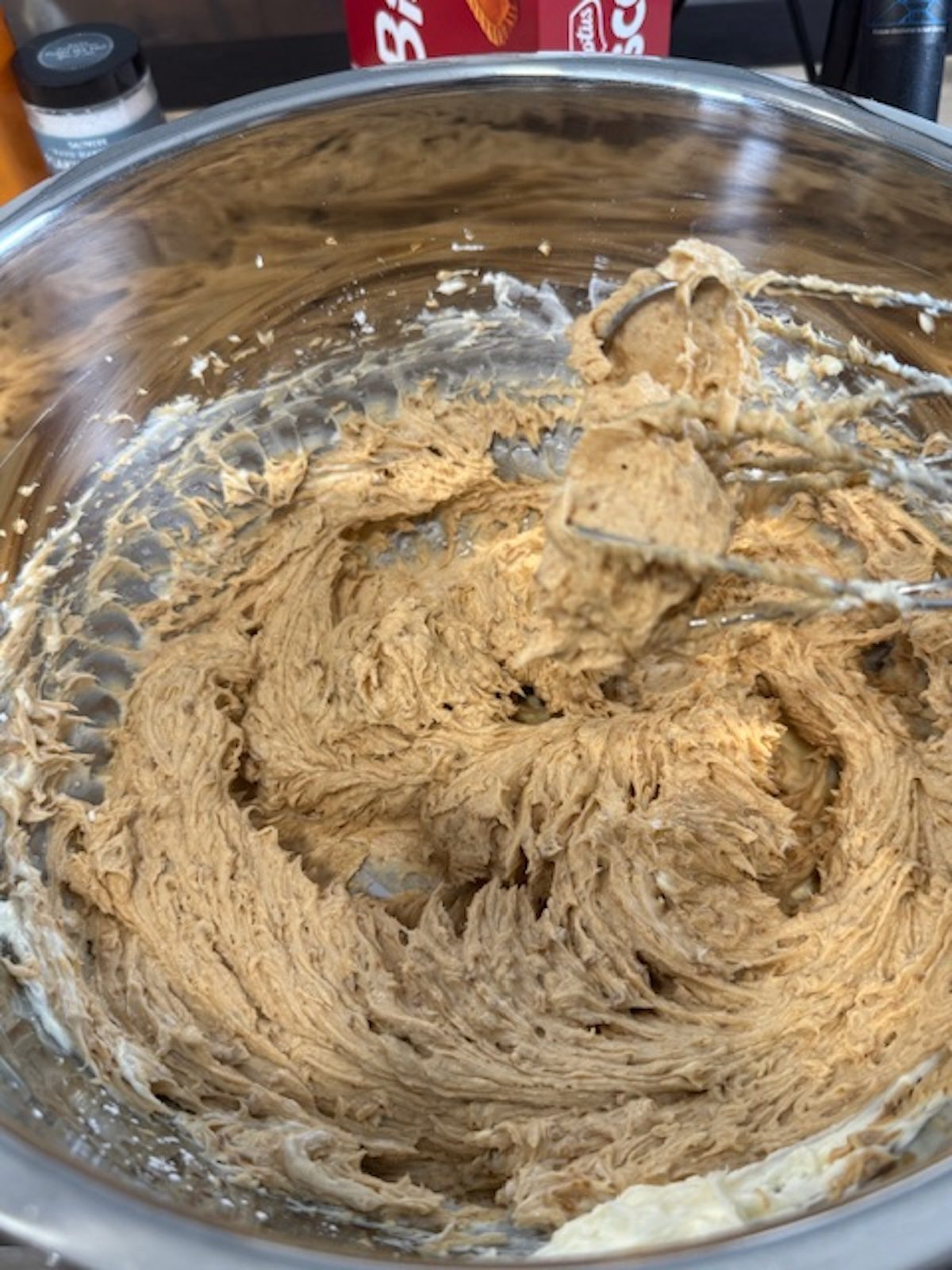 A metal bowl with no bake biscoff cheesecake filling.