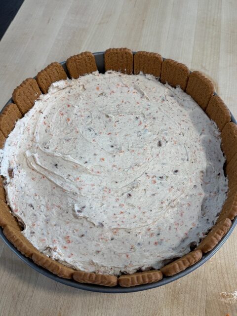 No bake carrot cake filling in the cake pan with biscoff cookie rim.