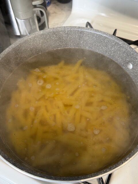 Pasta boiling in a gray pot on the stovetop.