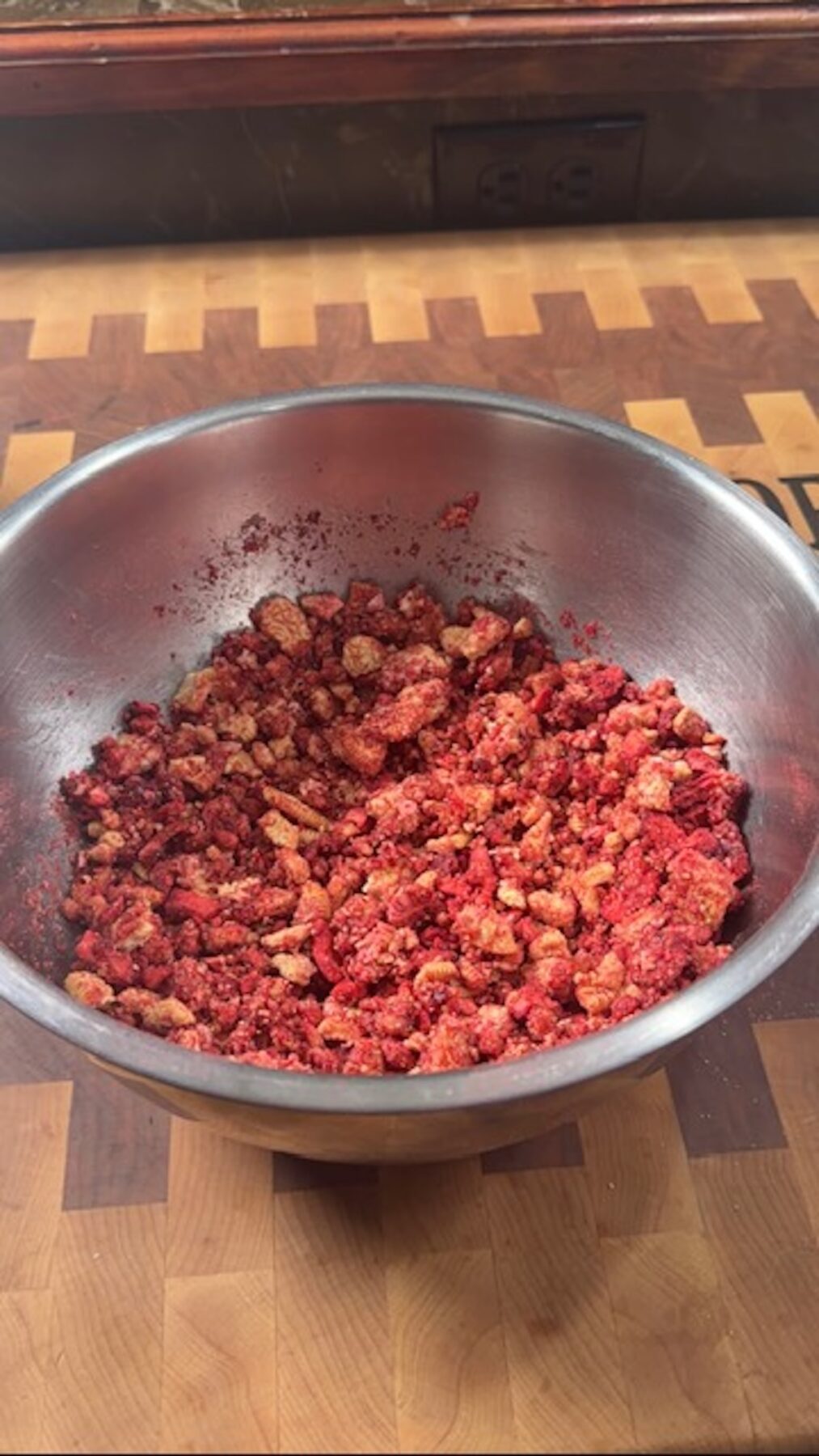 A metal bowl with strawberry crunch.