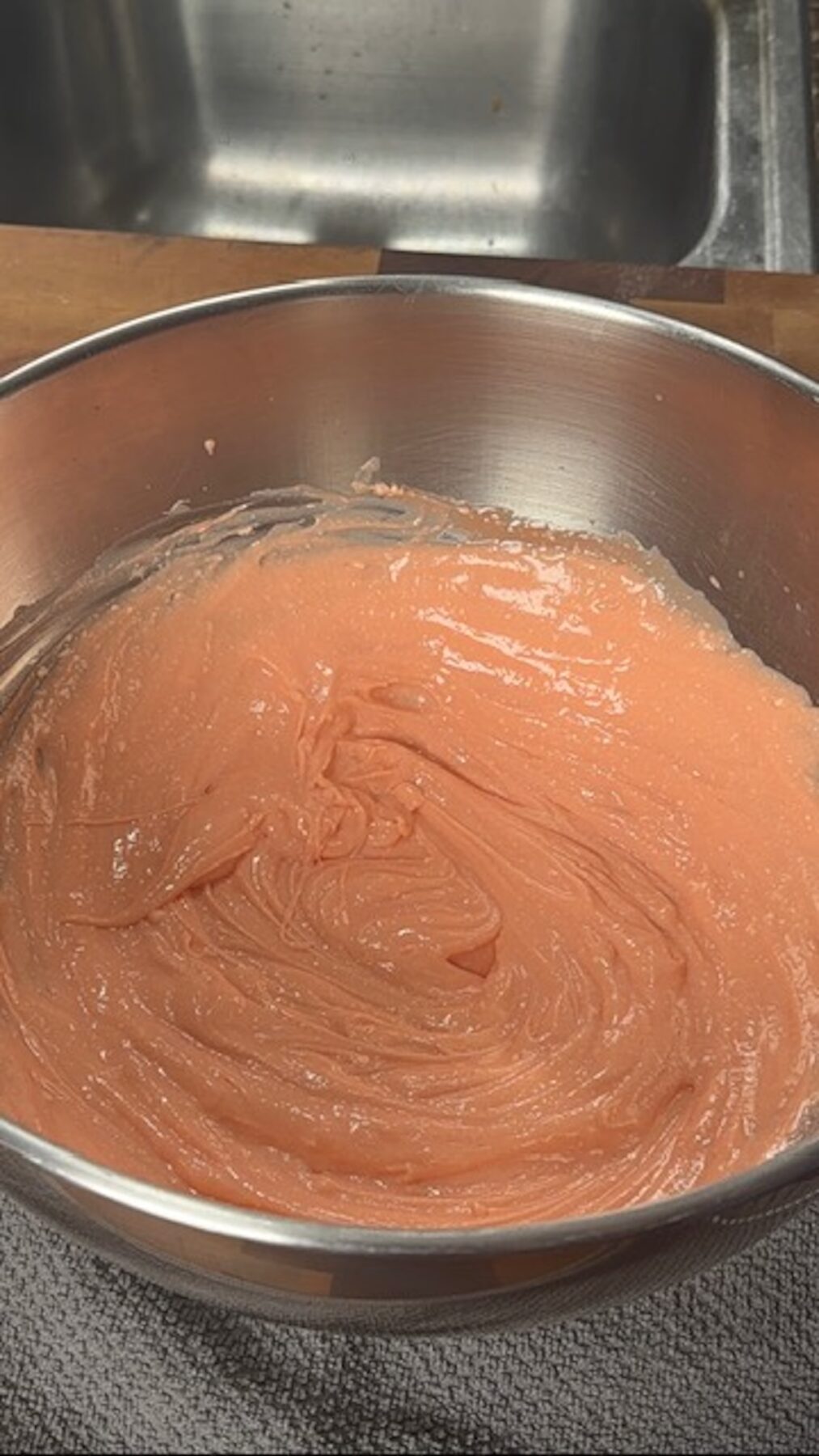 A metal bowl with strawberry pudding mixture.