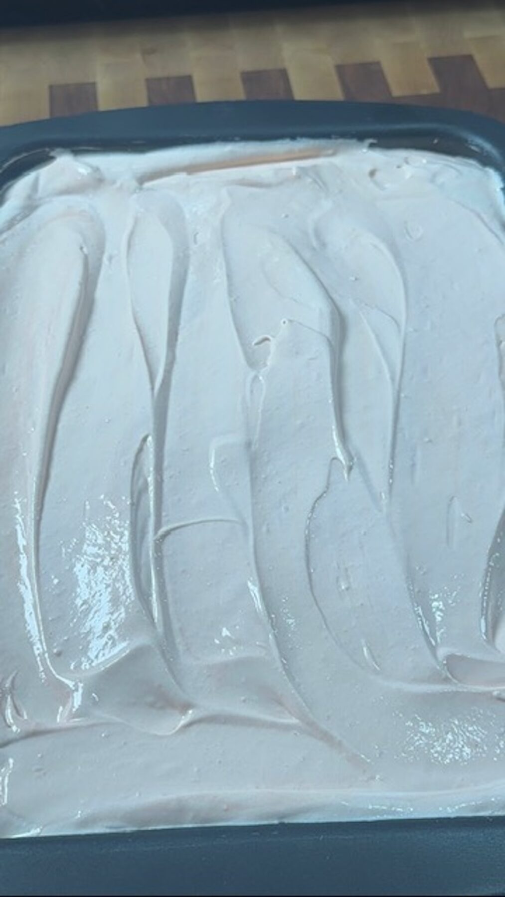 A strawberry tres leches cake with whipped cream spread over the top.