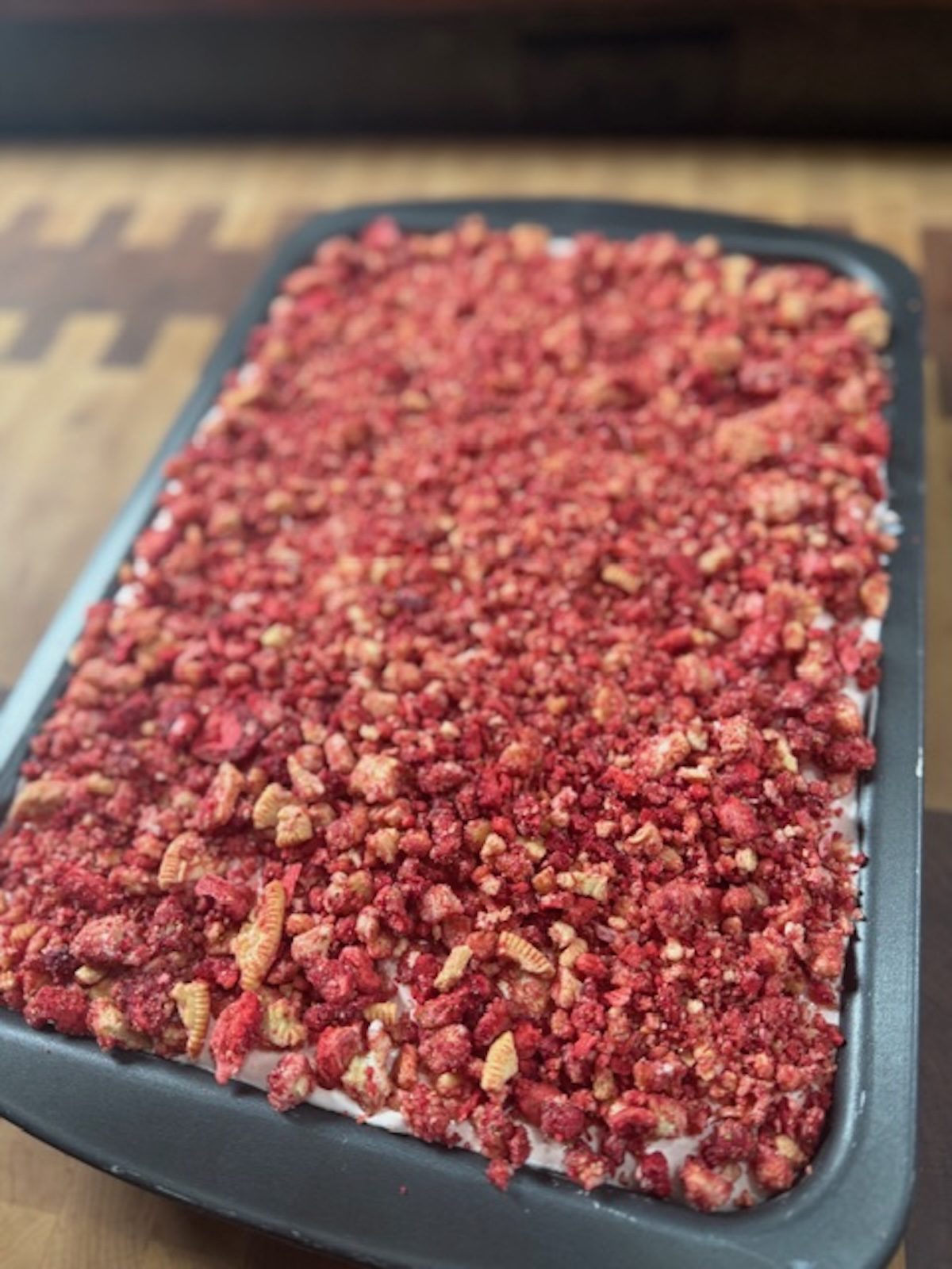 A close up view of strawberry tres leches cake with crunchy topping.