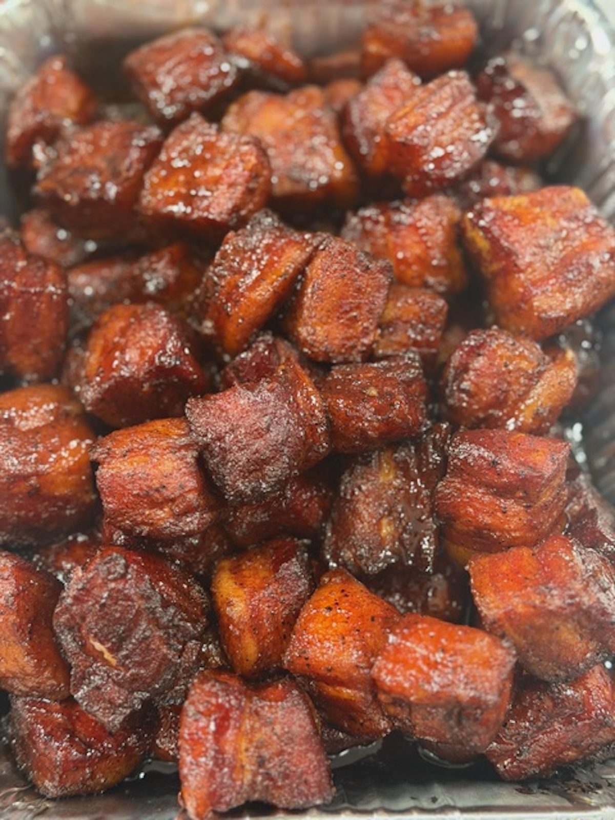 Pork belly burnt ends in a silver tray.