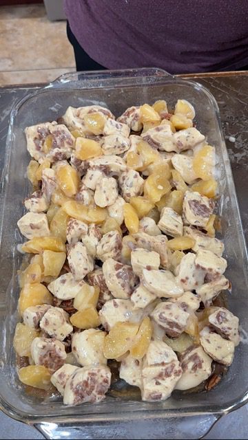 A glass baking dish with the biscuit pieces and apples mixed.