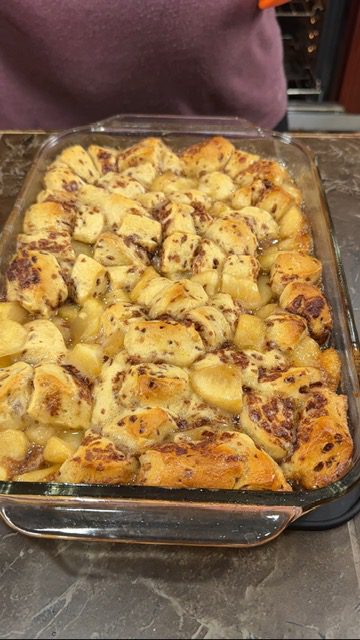 A glass baking dish with baked apple pie and biscuits baked for apple pie bubble bake.