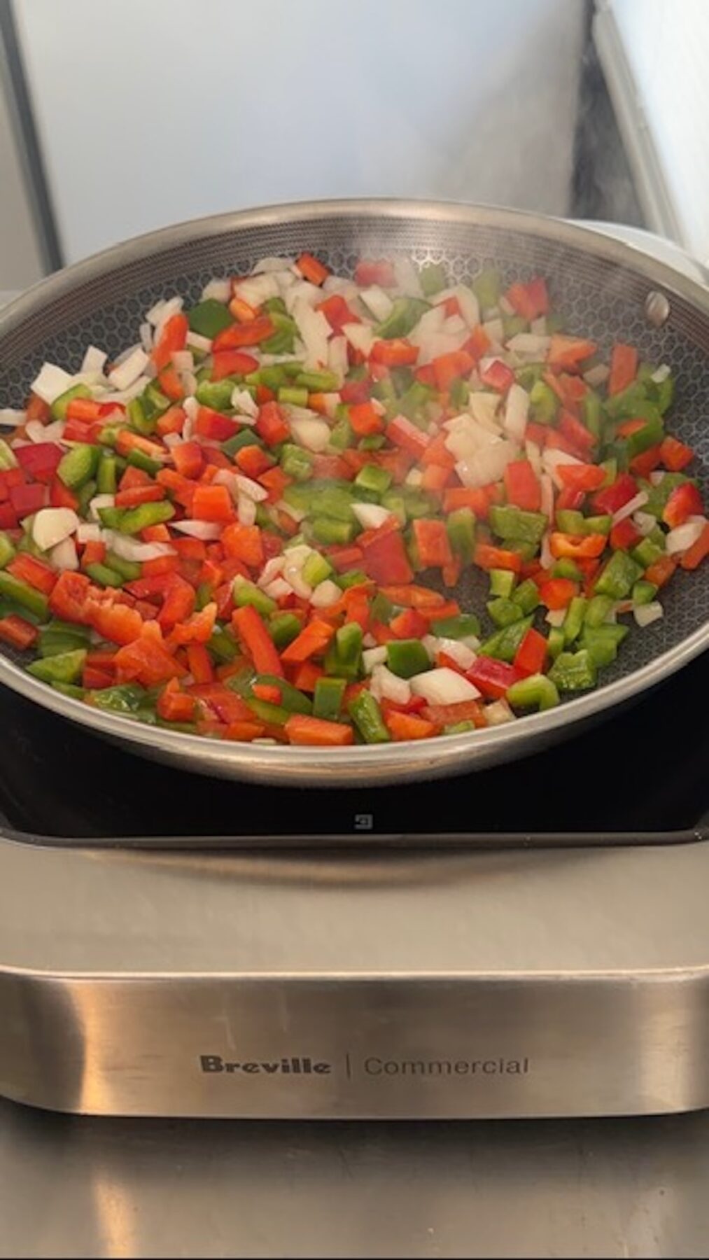 peppers and onions in pan cooking