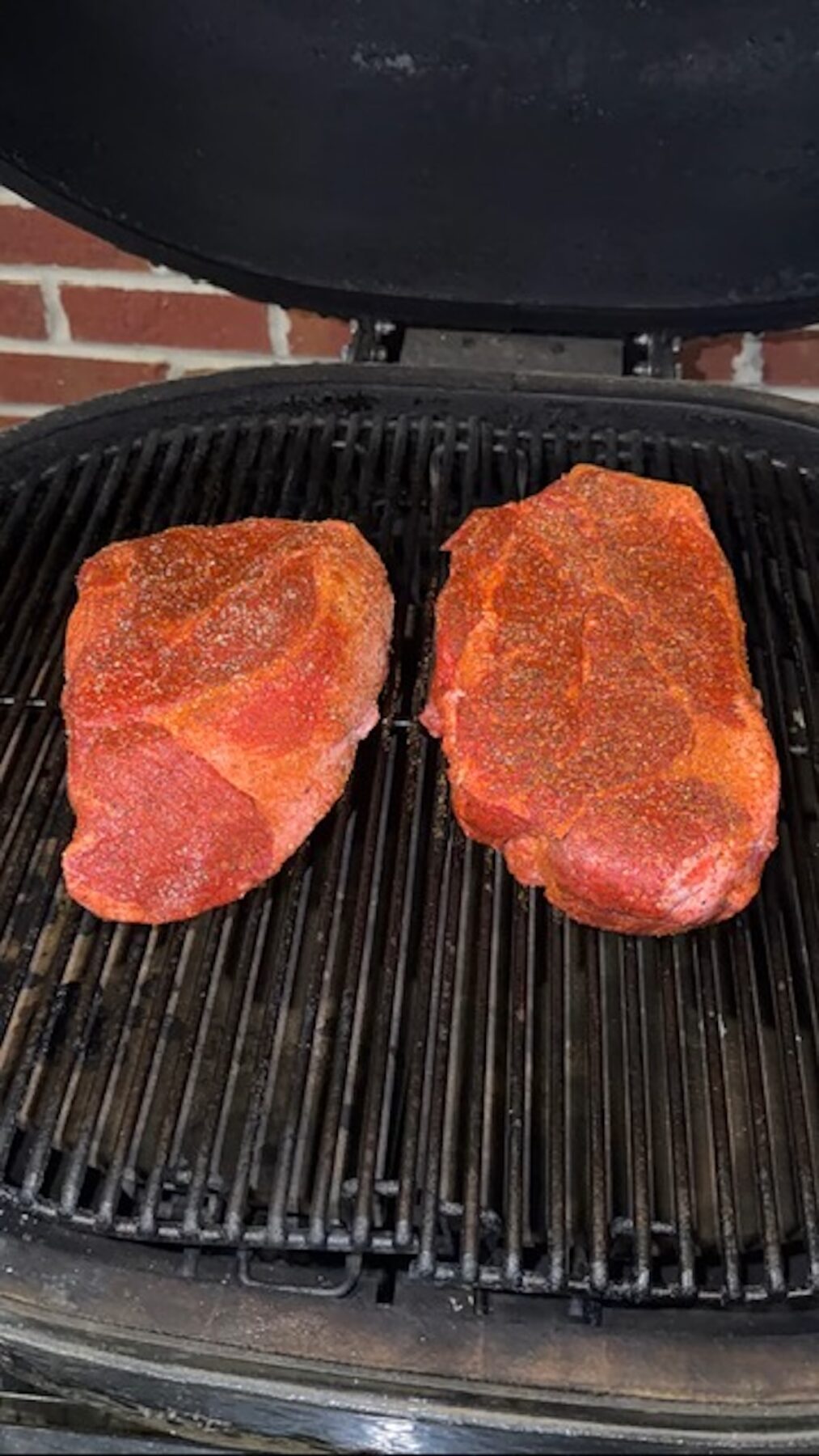 uncooked seasoned beef on smoker grates