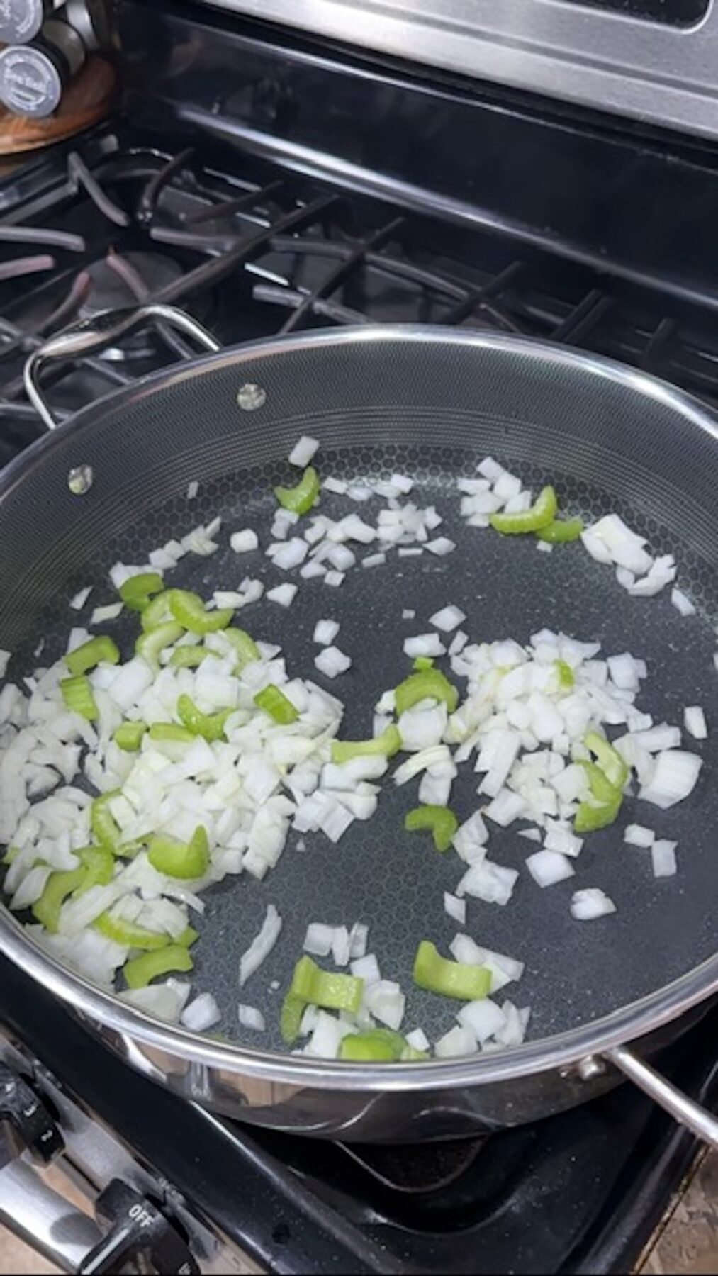 Saute pan with onion and celery cooking.
