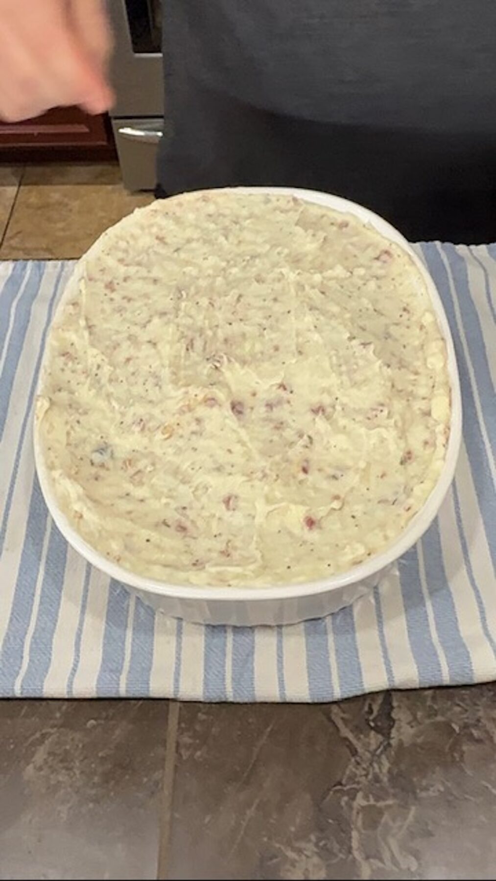 A baking dish with cottage pie assembled and mashed potatoes on top.