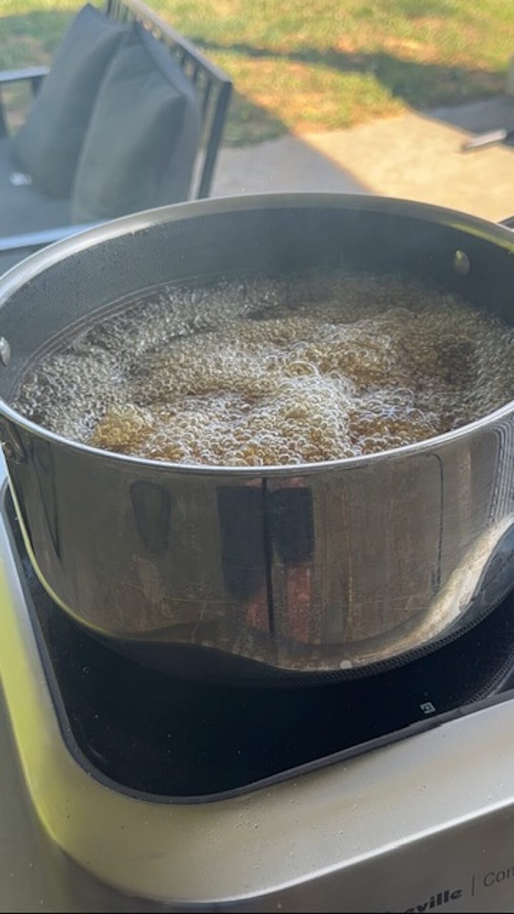 trash wings frying in oil. oil bubbling in pot.
