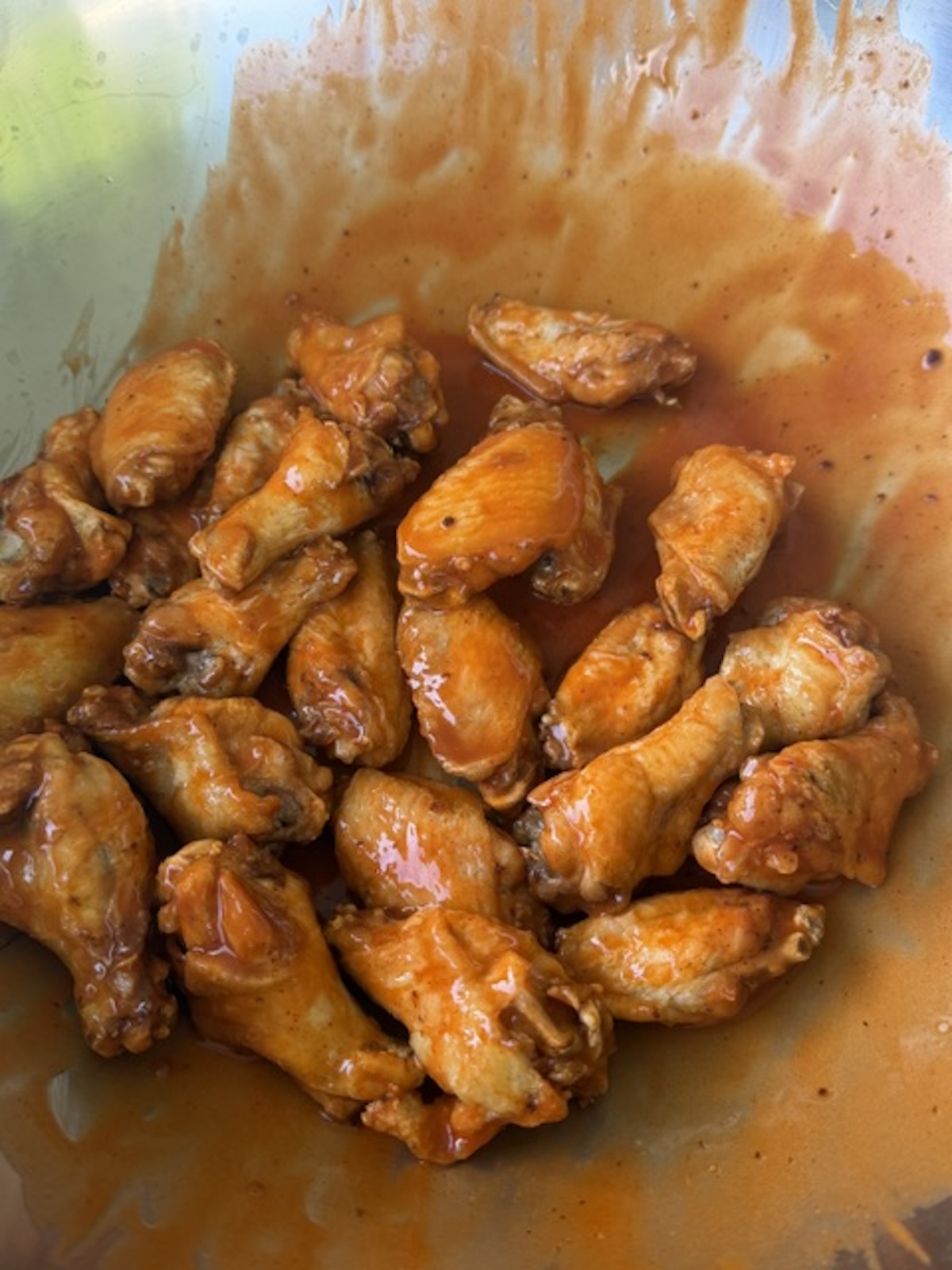 trash wings being tossed in sauce