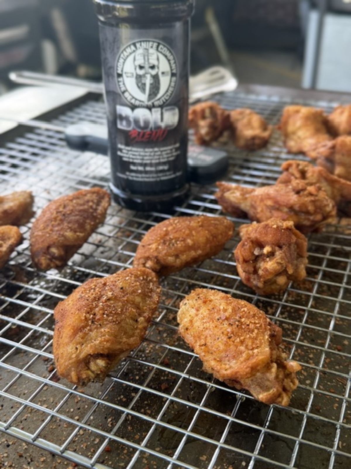 trash wings on rack with seasoning rub in bottle on rack