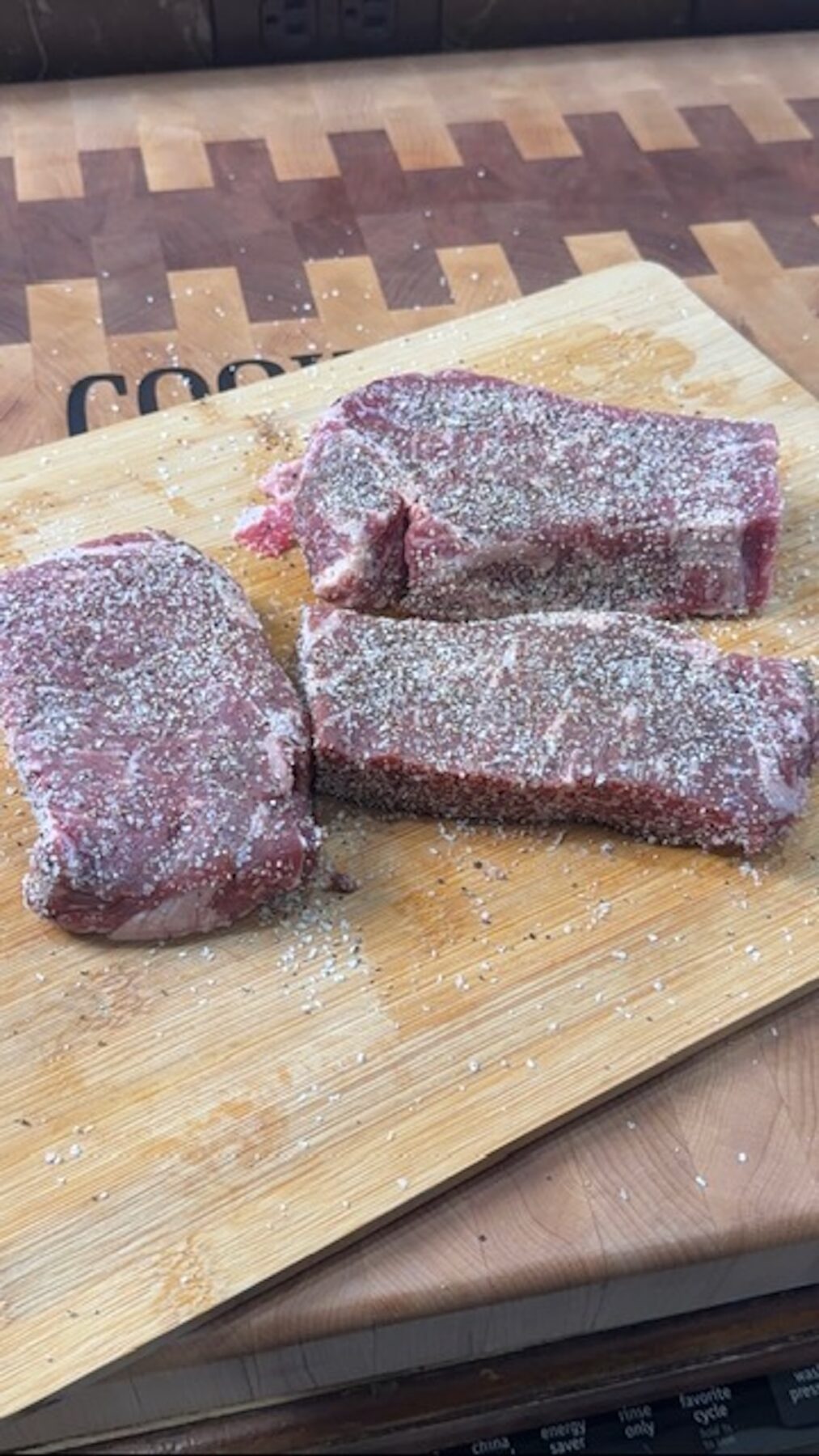 Steaks salted on a cutting board.