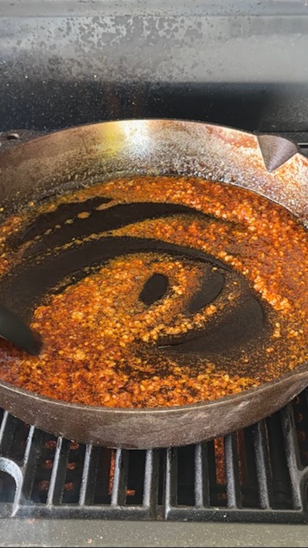Cast iron on a grill with butter and spices.