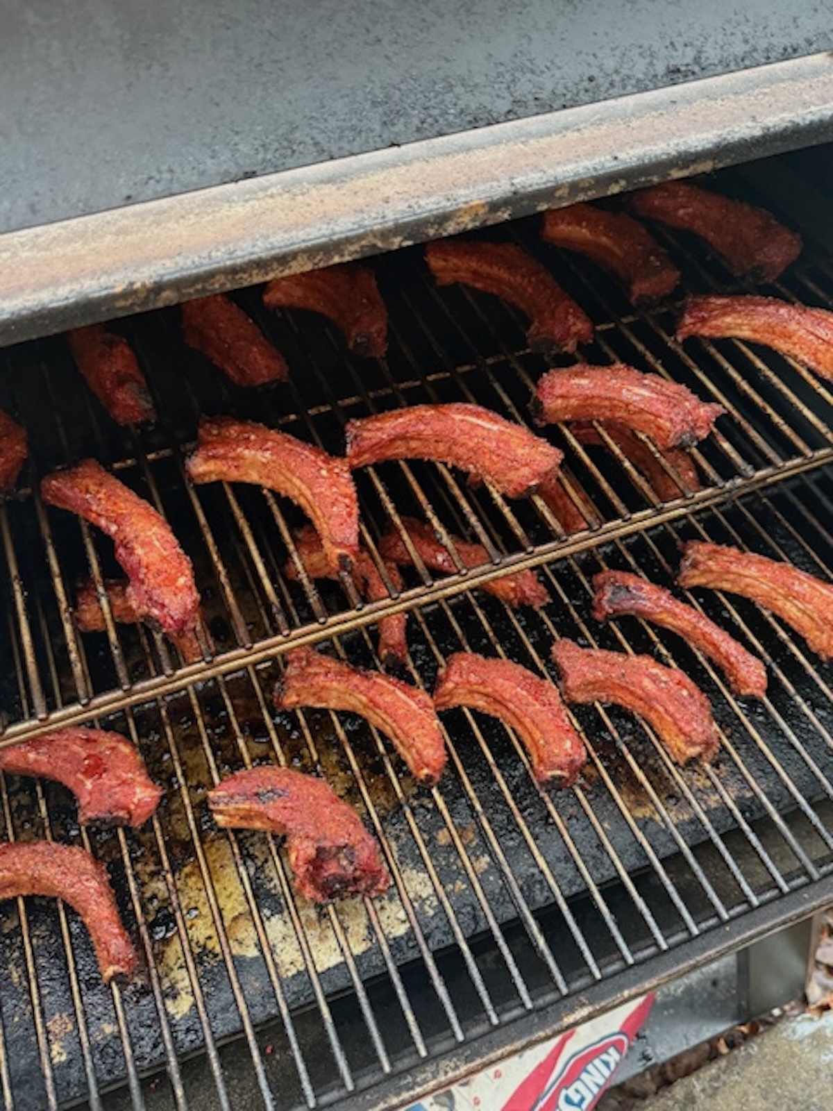 party ribs cooking on grill/smoker in individual servings
