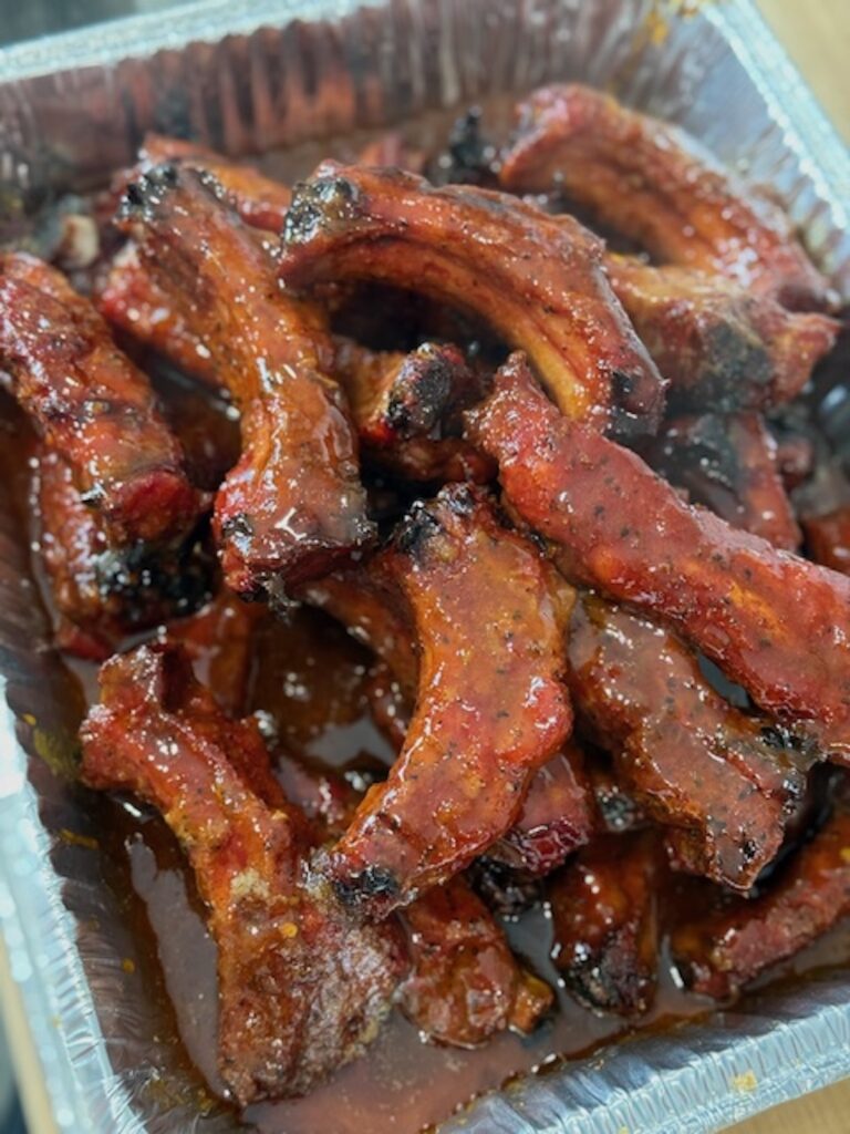 party ribs sauced and cooked, and cut, in aluminum tray
